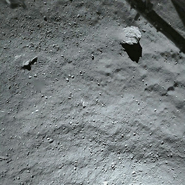 Image prise par ROLIS alors que Philae se situait à près de 40 m de la surface. Le gros bloc mesure environ 5 m et les plus petits détails font quelques cm. En haut, une portion du train d’atterrissage est visible. Crédits : ESA/Rosetta/Philae/R...