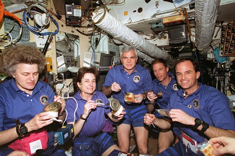L&#039;équipage amériacain de la mission STS-76 partage un repas russe avec les cosmonautes de la station MIR ; crédits Nasa